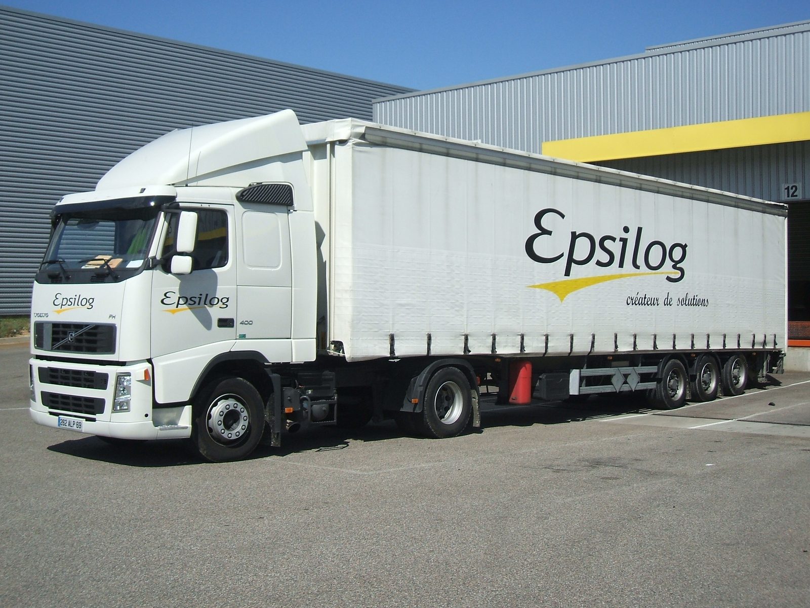 Ensemble routier Epsilog stationné devant un bâtiment logistique